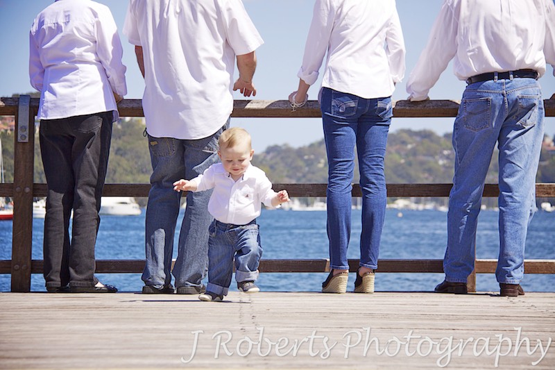 Little boy running away from parents & grandparents - family portrait photography sydney